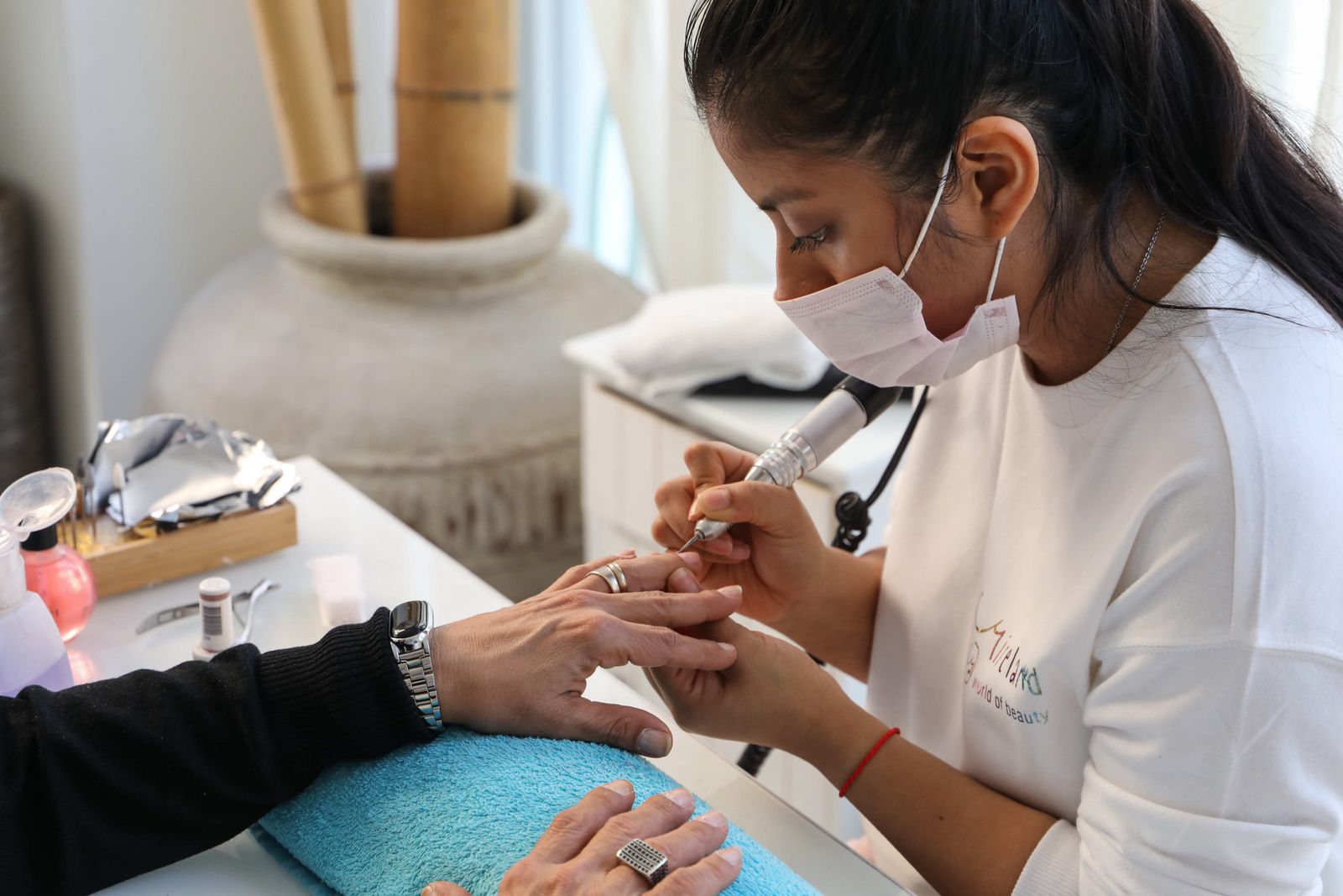 Nail technician carrying out a professional manicure service